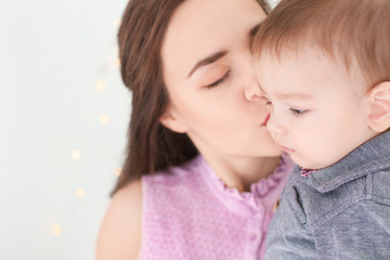 Loving mother with her baby on light background