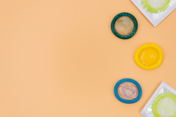 Top view colourful condoms on orange background