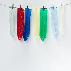 Colourful condoms on clothesline with clothes-pins