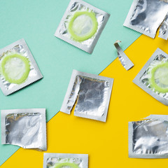 Above view condoms on green and yellow background