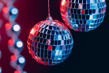 Sparkling disco balls hanging in the air against black background