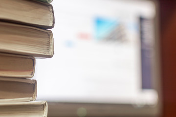 Books and computer. Several books with a monitor in the background. The concept of study, distance learning, education.