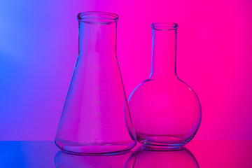 Chemical glassware close up on neon pink-purple background