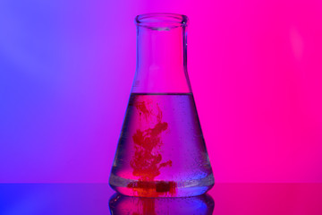 Laboratory glass tubes with chemicals on bright pink background