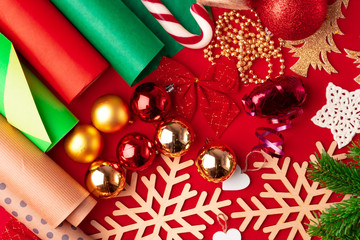 Close up shot of wrapping paper and items for christmas decorating on red background