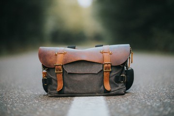 Closeup shot of a leather hiking bag on a road - Powered by Adobe