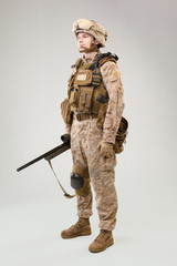 Studio shoot of modern infantry soldier, U.S. marine rifleman in combat uniform, helmet and body armor