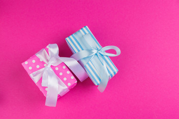 Top view of a decorated present with a bow on pink background