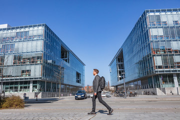 Young businessman commuter walking commuting to work going to office early morning on Copenhagen...