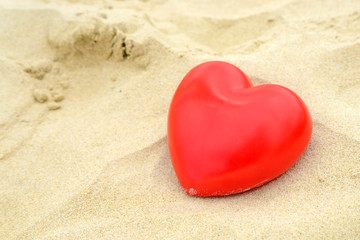 Fototapeta na wymiar Heart on the sand on the summer beach. Close-up.