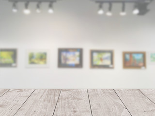Art gallery of creative painting on the wall with wooden table foreground for display products advertising background