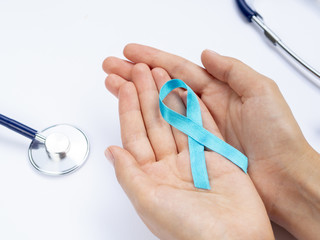Close-up hands holding blue ribbon with stethoscope