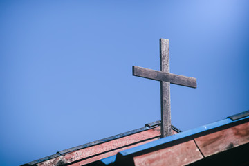 Christian cross on church with blue sky background.