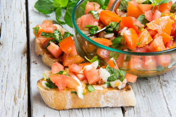 Ingredients to make bruschetta, typical Italian appetizer with tomato, basil and toast