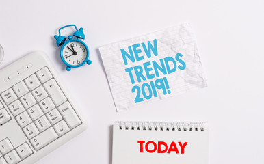 Text sign showing New Trends 2019. Business photo showcasing general direction in which something is developing Blank paper with copy space on the table with clock and pc keyboard