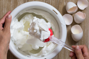 Hand of woman showing the whisked egg whites