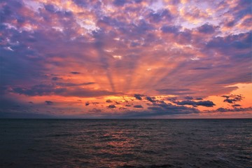 a sunrise with clouds on the sea beach