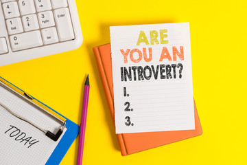 Writing note showing Are You An Introvertquestion. Business concept for demonstrating who tends to turn inward mentally Pile of empty papers with copy space on the table