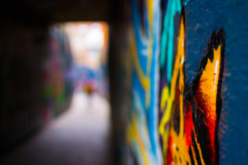Fototapeta na wymiar Close up of a red and orange graffity in Werregarenstraat (Graffiti Street) in Ghent, Belgium, Europe, with defocused background. Colorful famous street in the old town of Ghent