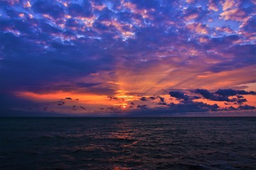 a sunrise with clouds on the sea beach