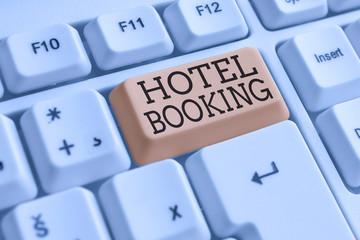 Conceptual hand writing showing Hotel Booking. Concept meaning Online Reservations Presidential Suite De Luxe Hospitality White pc keyboard with note paper above the white background