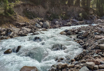 Trans-Ili Alatau mountain range of the Tien Shan system in Kazakhstan near the city of Almaty. Rocky peaks covered with snow and glaciers in the middle of summer under clouds
