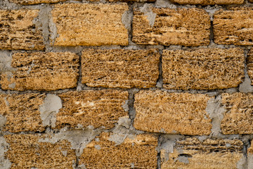 Brick wall of yellow shell rock. Closeup of shellstone texture. Background wall with shell rock. Old wall. Texture limestone