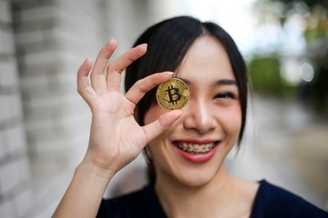 Selective of focus with Businesswoman holding the bitcoin gold coin,Digitall symbol of a new virtual currency concept.