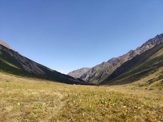 Trans-Ili Alatau mountain range of the Tien Shan system in Kazakhstan near the city of Almaty. Rocky peaks covered with snow and glaciers in the middle of summer under clouds