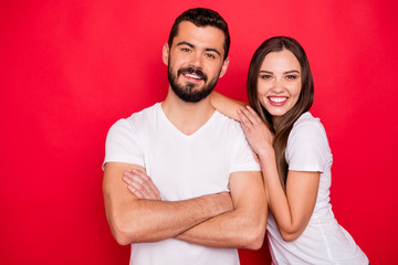 Photo of cute nice handsome beautiful couple of spouses friendly and kindly looking at you while isolated with red background