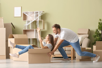Young couple having fun after moving into new house