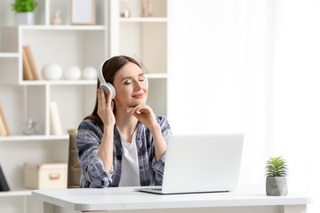 Young woman relaxing and listening to music at home