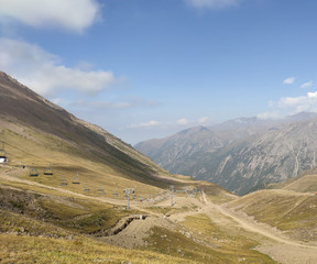 Trans-Ili Alatau mountain range of the Tien Shan system in Kazakhstan near the city of Almaty. Rocky peaks covered with snow and glaciers in the middle of summer under clouds