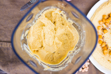 Original homemade arabic chickpea hummus with olive oil and cumin. Creamy dip paste. Blender or food processor with made hummus paste.