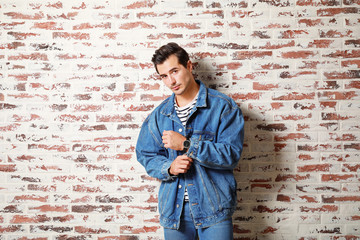 Stylish fashionable man near brick wall