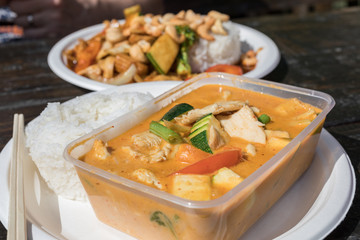 Thai food take away in plastic container and on a paper plate. 