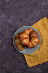 fresh croissants on a lilac background