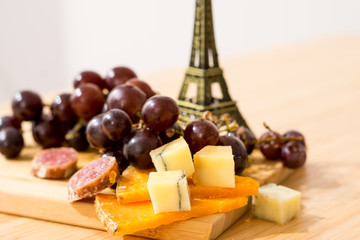 French cheese with grape on the small  Eiffel Tower background