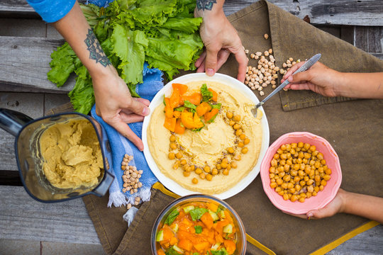 Original Homemade Arabic Chickpea Hummus With Olive Oil And Cumin. Creamy Dip Paste. Adult Woman And Child, Kid Hands Have Food Together. Family Lunch.