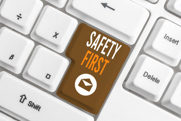 Conceptual hand writing showing Safety First. Concept meaning used to say that the most important thing is to be safe White pc keyboard with note paper above the white background