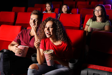 Couple with popcorn watching movie in cinema