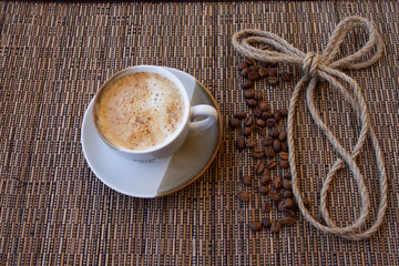 cup of coffee coffee beans cinnamon on a brown background