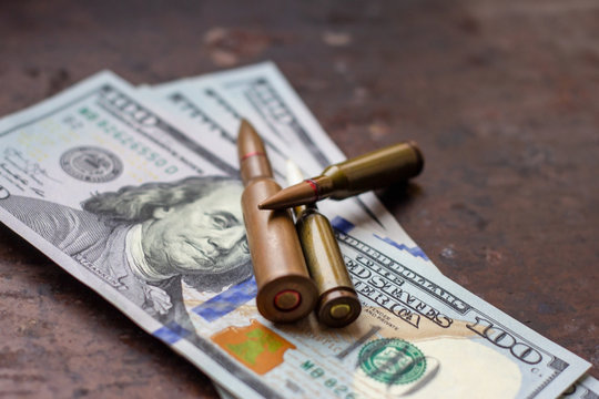 Diverse weapon bullets on American dollars background. Military industry, war, global arms trade and crime concept