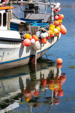 Bojen eines Schiffes spiegeln sich im blauen Wasser im Hafen von Mevagissey, England