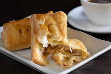 Tuna Pie in white dish and black coffee in cup, all on dark wooden background
