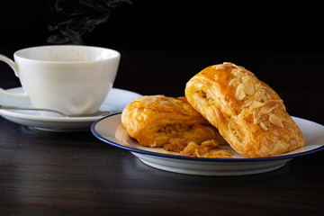 Chicken Pie sprinkle with dry pumpkin seed in white dish and black coffee in cup, all on dark wooden background