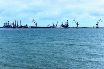 Heavy Loader of a Harbour Wharf Lifting Cargo Ship