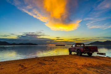 Old pickup truck parked on the waterfront with sunset at Bang phra reservoir ,sriracha chon buri,  thailand - obrazy, fototapety, plakaty