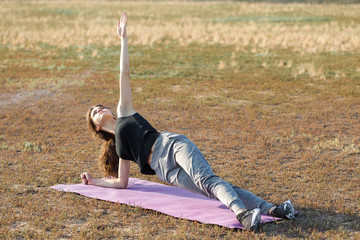 A young slim athletic girl in sportswear with snakeskin prints performs a set of exercises. Fitness...