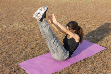 A young slim athletic girl in sportswear with snakeskin prints performs a set of exercises. Fitness...